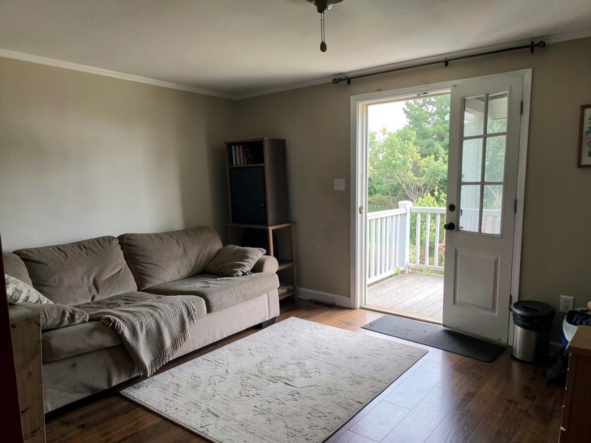 A living room in a single-level home with a door open onto a deck